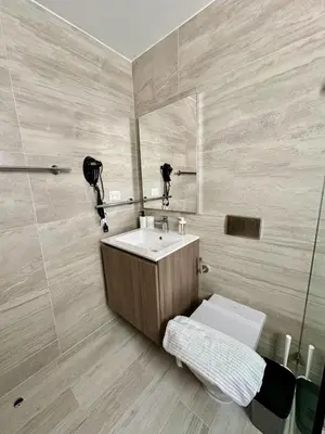 a bathroom with a sink and a toilet and a mirror at Corner 2BDR in Coral Bay 2 in front of Hard Rock in Punta Cana