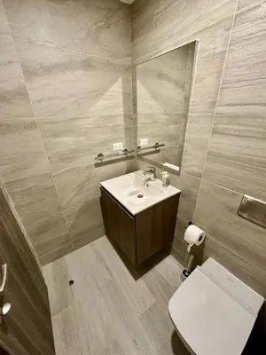 a bathroom with a sink and a mirror and a toilet at Corner 2BDR in Coral Bay 2 in front of Hard Rock in Punta Cana