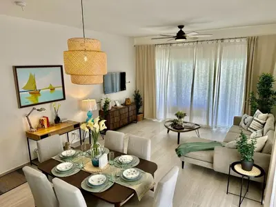a living room with a table and a dining room at Corner 2BDR in Coral Bay 2 in front of Hard Rock in Punta Cana