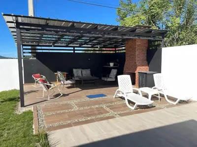 a pavilion with chairs and a table and a grill at Villa Ferrer I in Jarabacoa