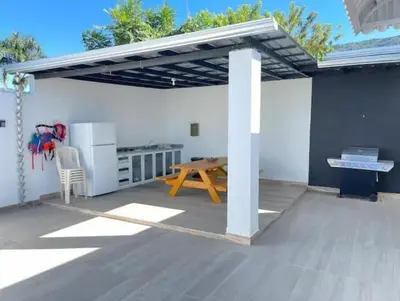 a patio with awning and a wooden table at Villa Ferrer I in Jarabacoa