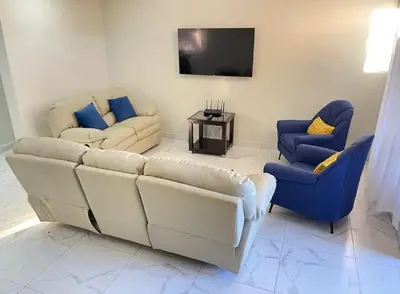 a living room with a couch and two chairs and a tv at Villa Ferrer II in Jarabacoa