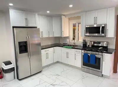 a kitchen with white cabinets and stainless steel appliances at Villa Ferrer II in Jarabacoa