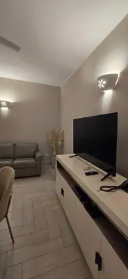a living room with a flat screen tv and a couch at Luxury apartment Tracadero 2 Bedrooms Sea Pools access Private Garden Workspace in La Laguna