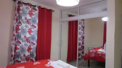 a bedroom with a mirror and a red curtain at Style and Comfort in Cancino