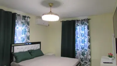 a bedroom with a bed with green and blue curtains at Style and Comfort in Cancino