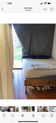 a picture of a bed in a room with a curtain at Devon Rodriguez art villa in El Naranjito