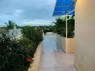 a balcony of a building with flowers and plants at Nice rooftop apartment in La Cabirma