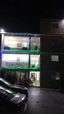 a building with a balcony with people sitting on the porch at Hotel 3 Hnos in Comendador
