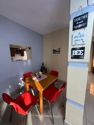 a dining room with a table and red chairs at Cielo Alto in Jarabacoa