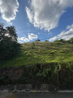 a green grassy hill with a blue sky and clouds at Cielo Alto in Jarabacoa
