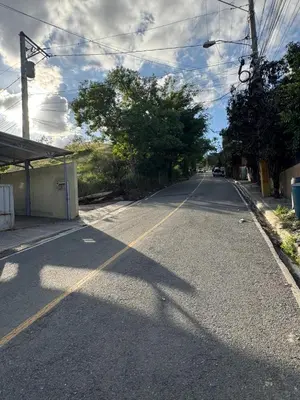 an empty street with trees on the side of the road at Cielo Alto in Jarabacoa