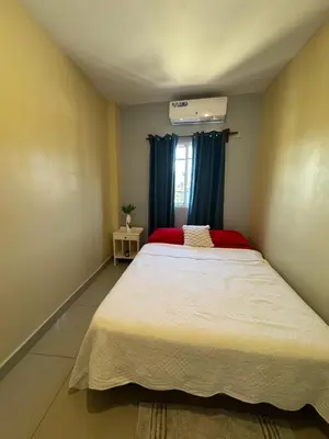 a bedroom with a large white bed with blue curtains at Cielo Alto in Jarabacoa