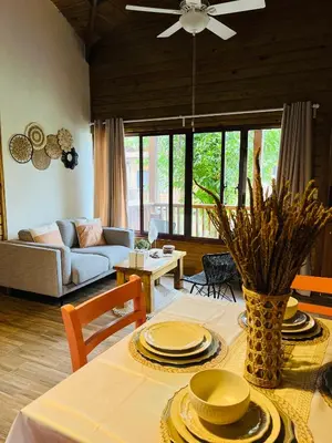 a living room with a table with plates on it at Estaciones de Jarabacoa-Mountain Lodge in Jarabacoa