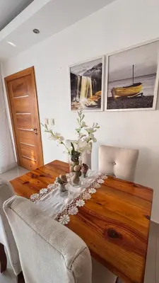 a wooden table with a vase of flowers on it at Coastal Apt, Near Malecón, 6 Guests 3 beds in La Romana
