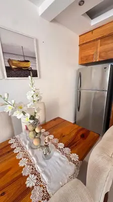 a kitchen with a wooden table and a refrigerator at Coastal Apt, Near Malecón, 6 Guests 3 beds in La Romana