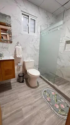 a bathroom with a toilet and a glass shower at Coastal Apt, Near Malecón, 6 Guests 3 beds in La Romana