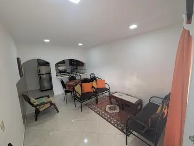 a living room with chairs and a table and a kitchen at small apartment in a downtown area in Cruce de Veragua
