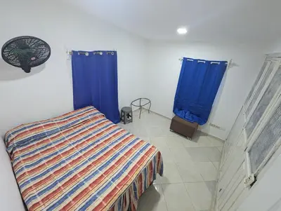 a bedroom with a bed and two blue curtains at small apartment in a downtown area in Cruce de Veragua