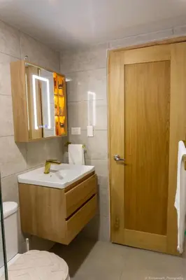 a bathroom with a white sink and a wooden door at Apartamento Ensanche Isabelita cercano Avenida España in La Viva