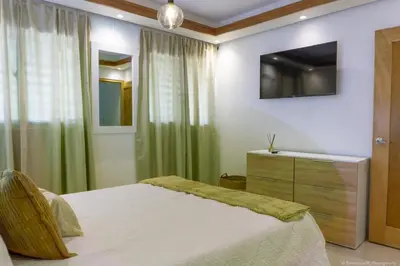 a bedroom with a bed and a television on the wall at Apartamento Ensanche Isabelita cercano Avenida España in La Viva