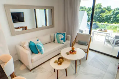 a living room with a white couch and a mirror at Refugio Ideal Golf & Piscina Cana Rock Star in Punta Cana