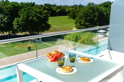 a table with two plates of food on a balcony at Refugio Ideal Golf & Piscina Cana Rock Star in Punta Cana