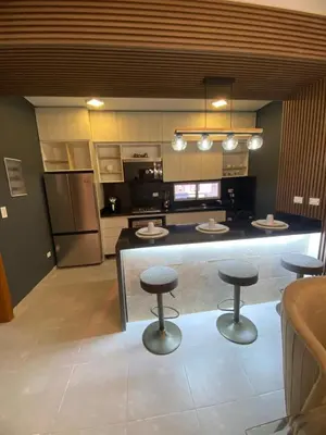 a kitchen with a counter with three stools in it at Luxury apto 3 rooms Mariel III at White Sand, Punta Cana in Punta Cana