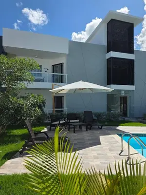 a building with a patio with an umbrella at Luxury apto 3 rooms Mariel III at White Sand, Punta Cana in Punta Cana