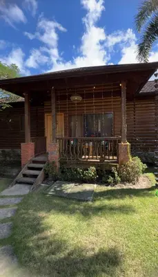 a wooden house with a porch and a balcony at Estaciones de Jarabacoa - Mountain Lodge in Jarabacoa