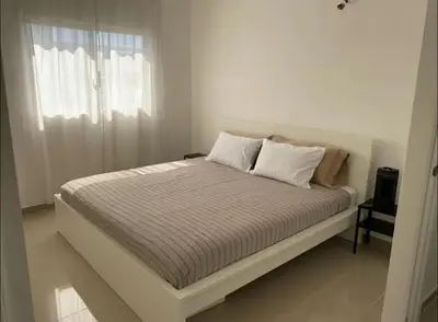 a bed in a white room with a window at Fully furnished 2 bedroom appart in Bayahibe
