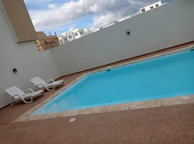 a swimming pool on the side of a building at Fully furnished 2 bedroom appart in Bayahibe