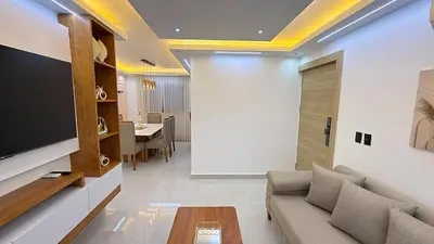 a living room with a couch and a tv at 3BR Condo by the Airport Pool Gym Parking Security in Santiago de los Caballeros