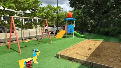 a playground with play equipment on the grass at 3BR Condo by the Airport Pool Gym Parking Security in Santiago de los Caballeros