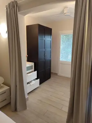 a room with a closet and a cabinet with curtains at Sunset Paradise Tracadero Apartment Sea pools access Private Garden WorkSpace in La Laguna