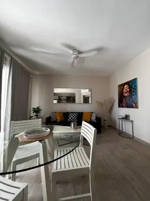 a living room with a glass table and white chairs at Sunset Paradise Tracadero Apartment Sea pools access Private Garden WorkSpace in La Laguna