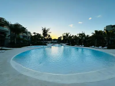a large swimming pool with chairs and palm trees at 1BR Tracadero Lodge, beach access & full amenities in La Laguna