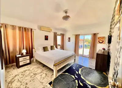 a bedroom with a bed and a large window at Villa Us Open in Sosúa