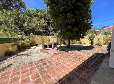 a brick walkway with a tree in a yard at Villa Us Open in Sosúa