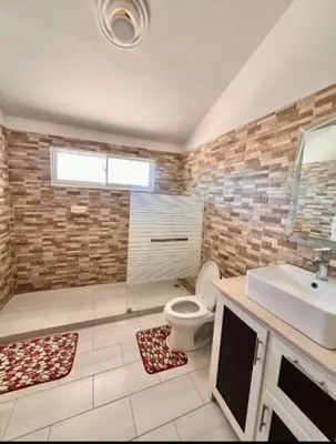 a bathroom with a toilet and a sink at Villa Us Open in Sosúa