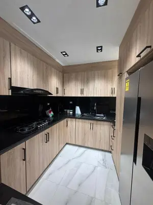 a kitchen with wooden cabinets and a black refrigerator at Villa la pal de 4 in La Ureña