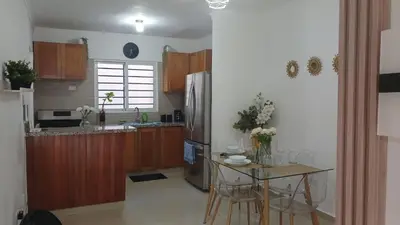 a kitchen with a stainless steel refrigerator and a table at Residencial Altos de Alameda in Peralejo