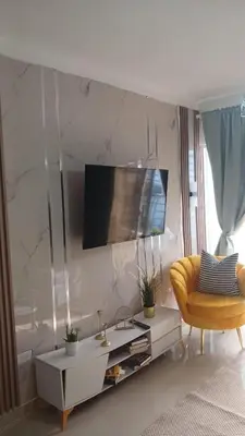a living room with a tv and a yellow chair at Residencial Altos de Alameda in Peralejo