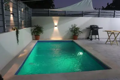 a swimming pool with green water in a backyard at Villa Yvelisse Pop Un paraíso próximo al Mar in San Felipe de Puerto Plata