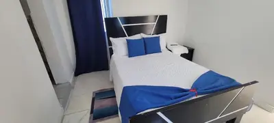 a bedroom with a bed with blue sheets and blue pillows at Hostal y Piscina in La Romana
