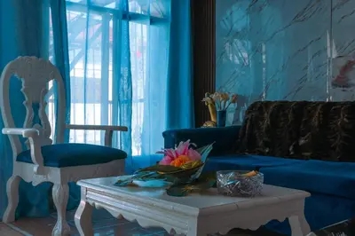 a living room with a couch and a table and a chair at Modesto Apartamento para dos personas cerca del centro de Puerto Plata in San Felipe de Puerto Plata