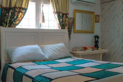 a bedroom with a bed with a quilt and a window at Modesto Apartamento para dos personas cerca del centro de Puerto Plata in San Felipe de Puerto Plata