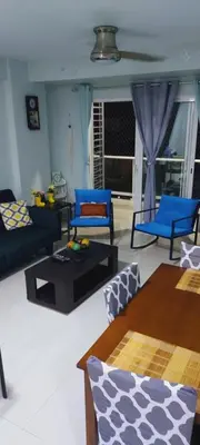 a living room with blue couches and a table at Cozy & Charming in Santo Domingo