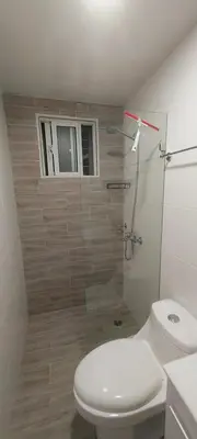 a bathroom with a toilet and a glass shower at Cozy & Charming in Santo Domingo