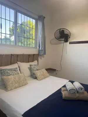 a bedroom with a bed with pillows and a window at La Española JW in Las Galeras